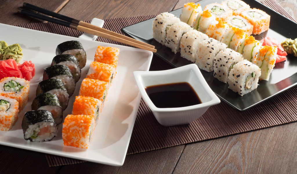 Суши на столе с соевым соусом и палочками