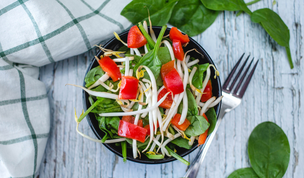 Овощной салат в миске на столе с вилкой