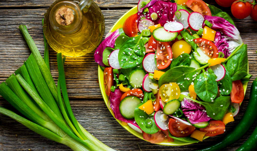 Овощной салат на столе с оливковым маслом и зеленым луком