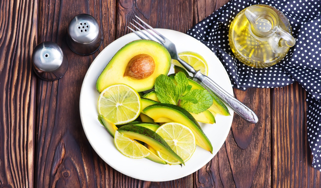 Авокадо и лимон нарезанный кусочками на тарелке