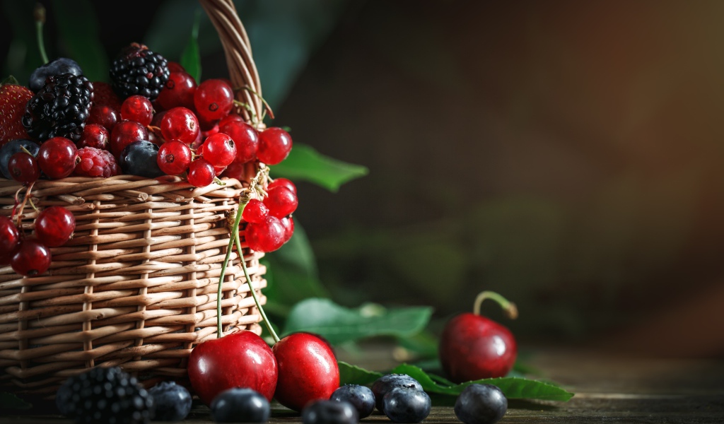 Корзина с ягодами черники, малины, красной смородины и черешни