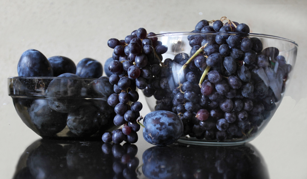 Синий виноград с синими сливами на столе