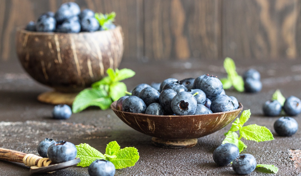 Ягоды черники стоят на столе в посуде