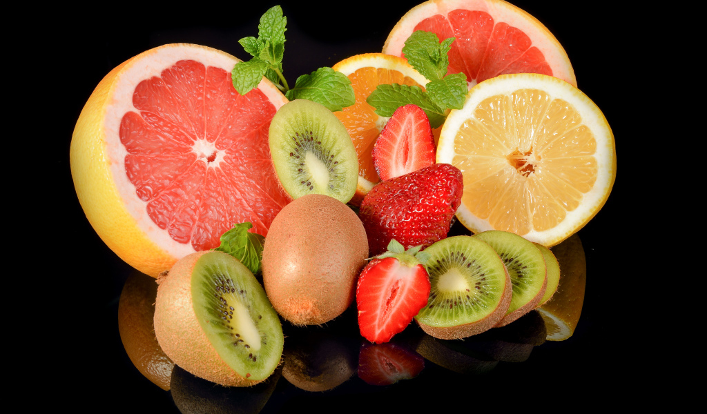 Цитрусовые фрукты на черном фоне с ягодами клубники 