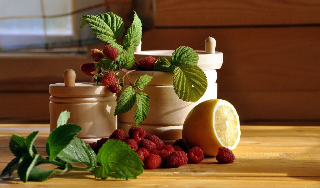 Посуда на столе с малиной и лимоном