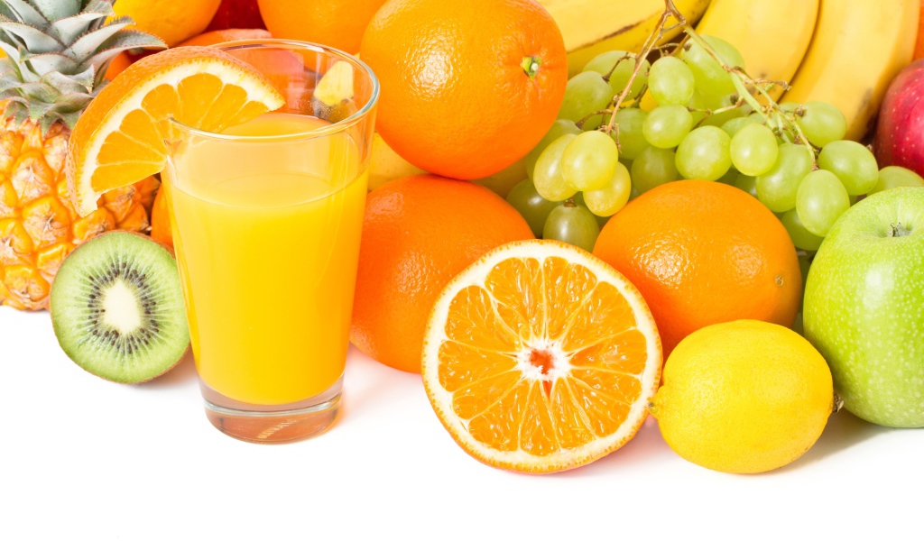 Свежие сочные фрукты на белом фоне со стаканом сока