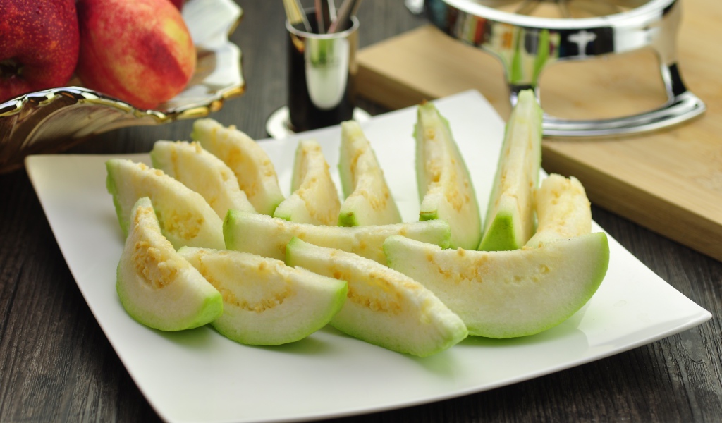 Кусочки плода гуава на белой тарелке