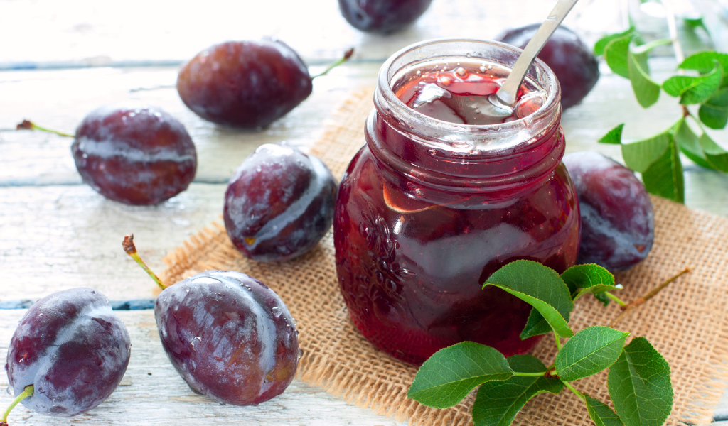 Джем в банке на столе со сливами