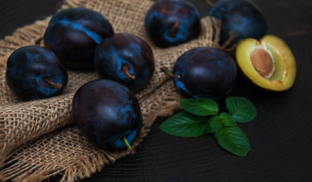 Спелые синие сливы на столе