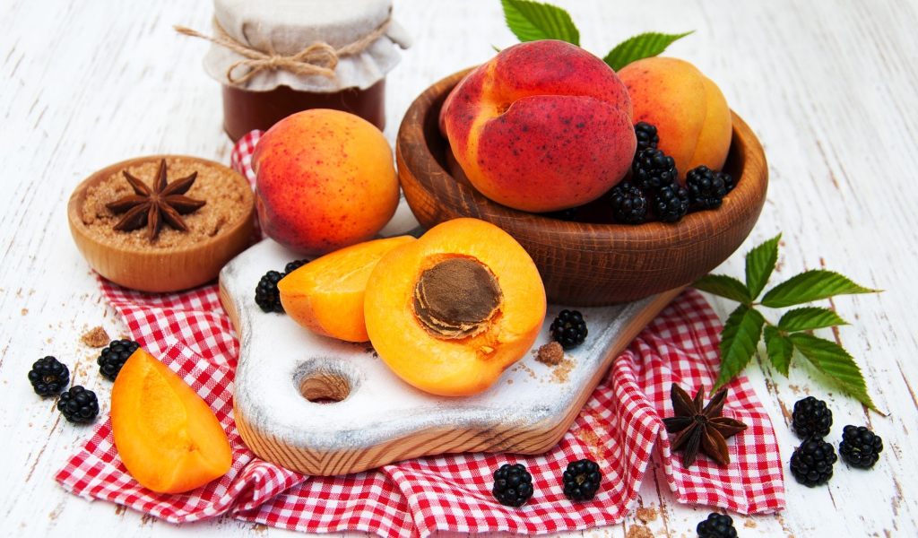 Спелые сочные абрикосы на столе с ягодами черники