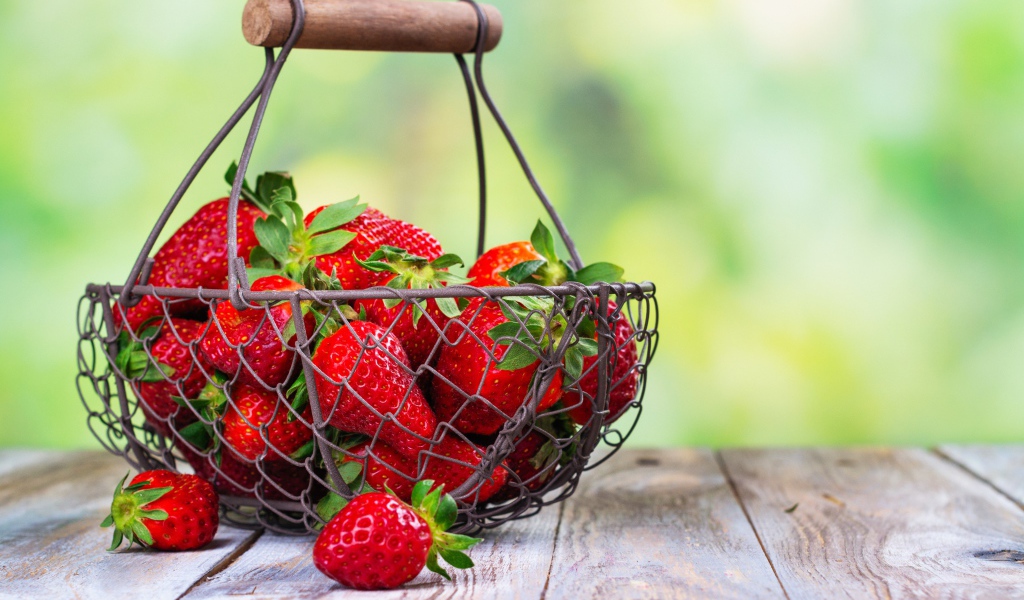 Спелая красная клубника в корзине на столе