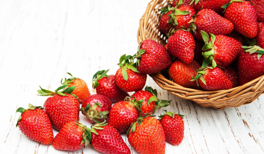 Клубника в корзине на деревянном столе