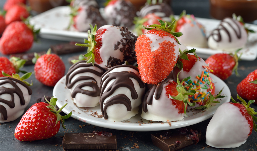 Клубника в шоколаде и сахаре на белой тарелке