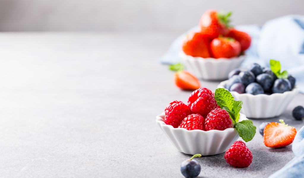 Ягоды клубники, малины и черники на столе 