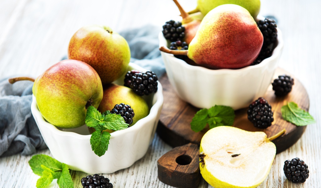 Вкусные груши на столе с ягодами ежевики