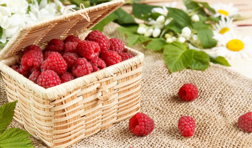 Плетеная корзина на столе с ягодами малины 