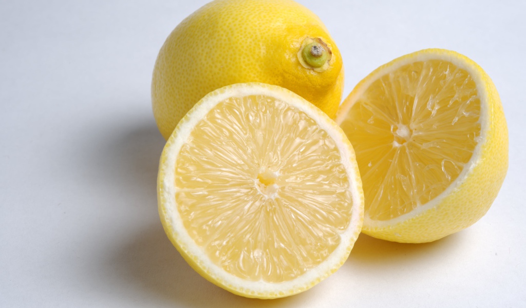 Желтые кислые лимоны на сером фоне