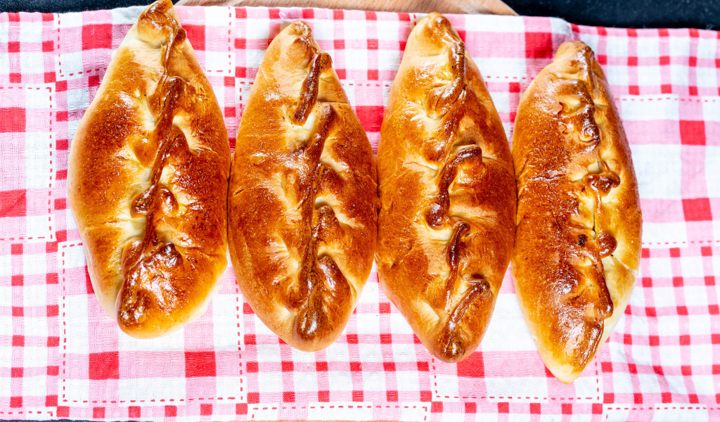 Аппетитные румяные пирожки лежат на полотенце 