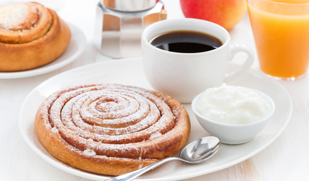 Чашка кофе на тарелке с выпечкой и сливками