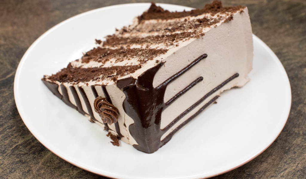 Кусок торта с кремом на белой тарелке