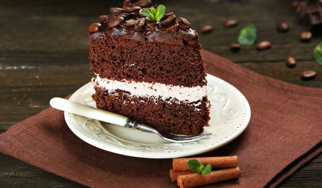 Кусок шоколадного торта с кремом и зернами кофе
