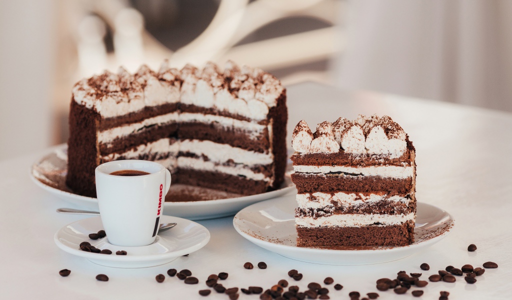 Аппетитный торт с чашкой кофе на столе
