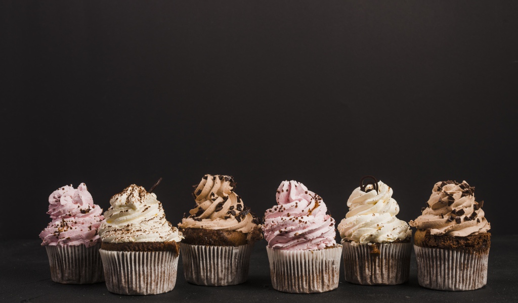 Аппетитные кексы с кремом на сером фоне