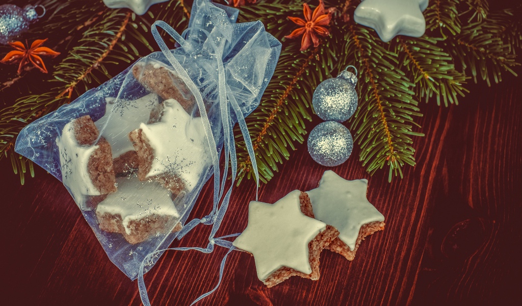 Аппетитное печенье звездочки в мешочке на столе с еловой веткой