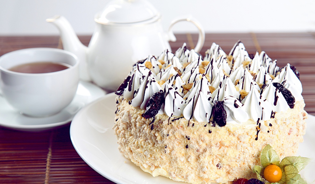 Красивый праздничный торт с безе на столе с чаем