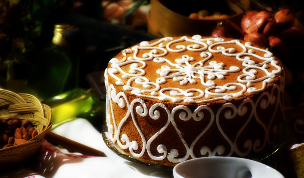 Красивый торт с белым рисунком  на столе