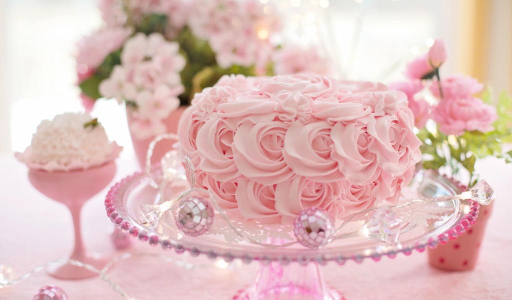 Красивый розовый торт на столе с цветами