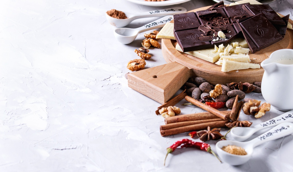 Черный и молочный шоколад на столе с орехами