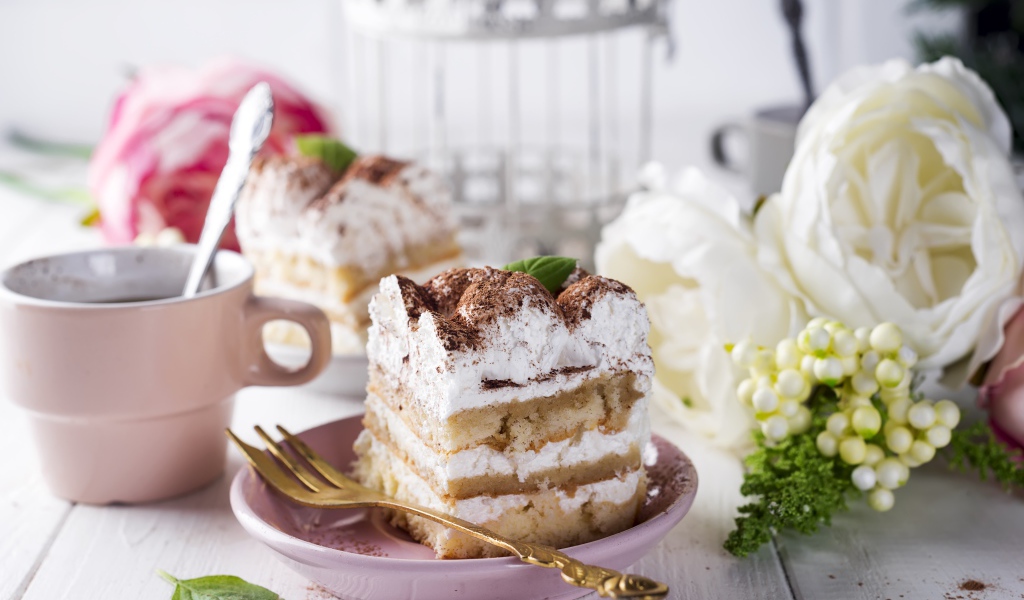 Пирожное на столе с кофе и цветами 