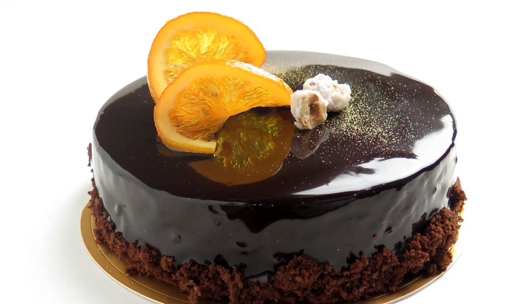 Торт с шоколадной глазурью и апельсинами на белом фоне