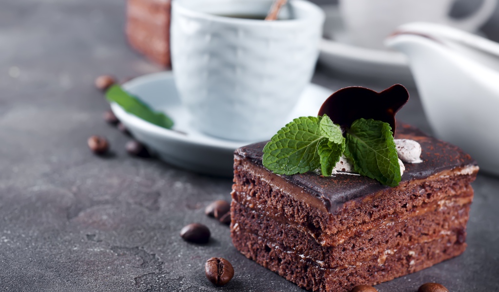 Шоколадное пирожное на столе с чашкой кофе