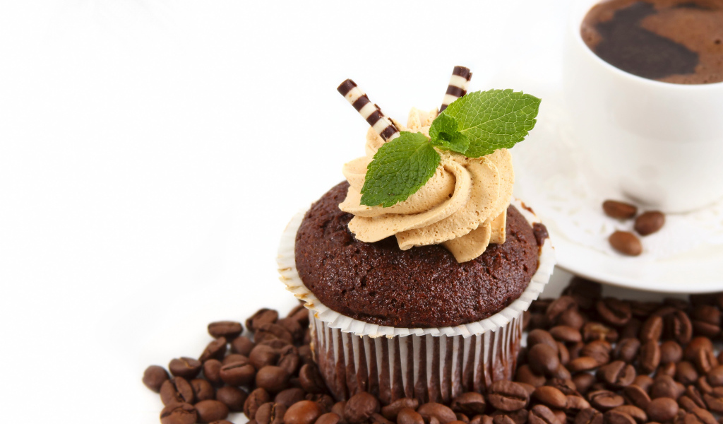 Шоколадный кекс с кремом на столе кофе и кофейными зернами