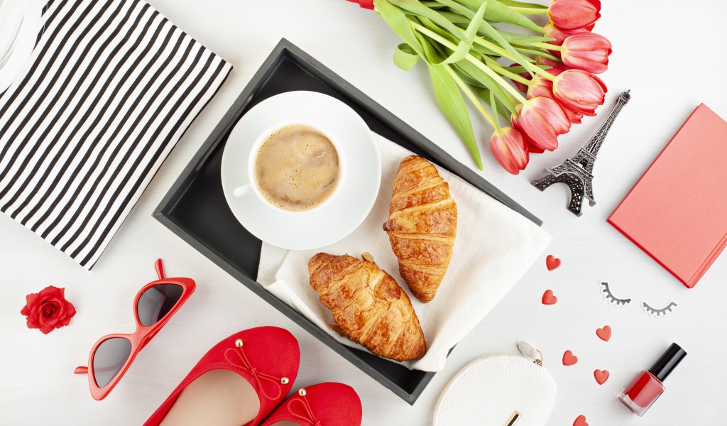 Coffee and croissants on the table with a bouquet for a loved one