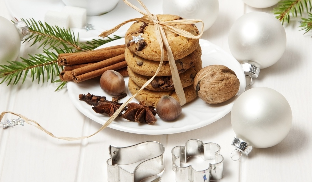 Печенье на тарелке с орехами и корицей на столе с игрушками 