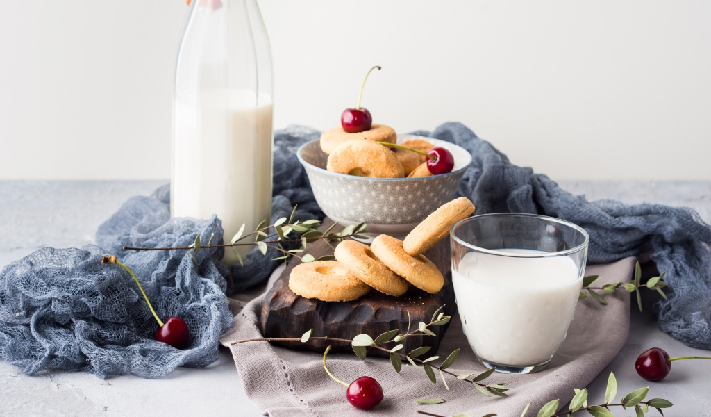 Печенье на столе с молоком и черешней