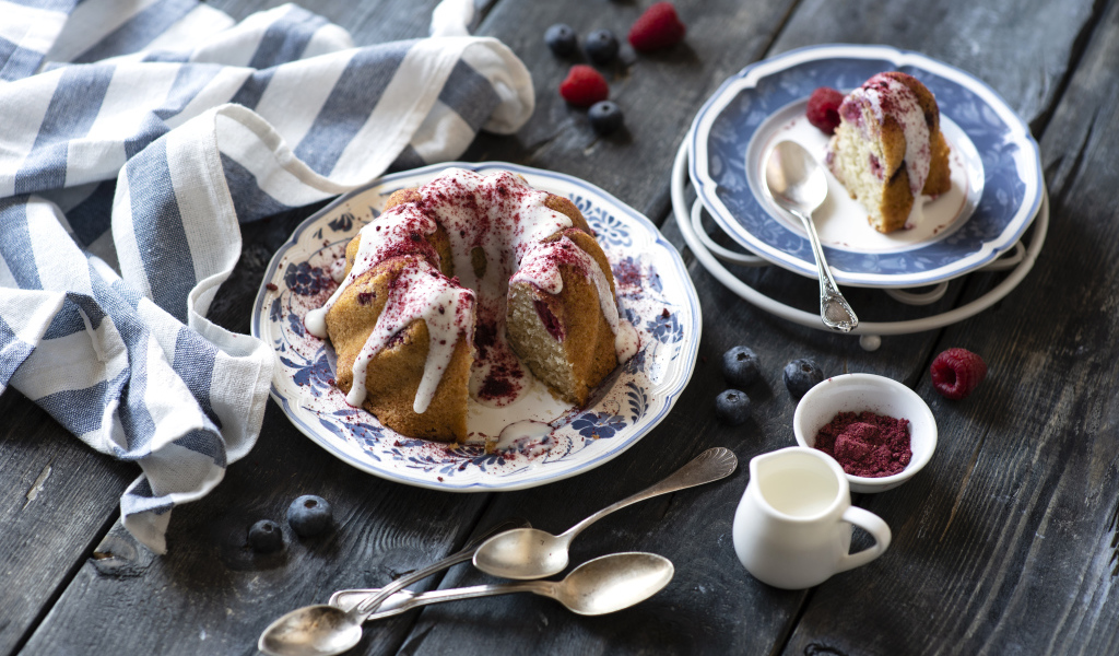 Кекс с кремом и ягодами на столе 