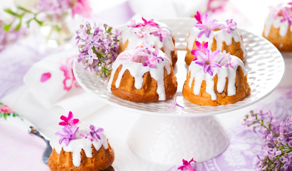 Кексы с глазурью на подносе с цветами сирени 