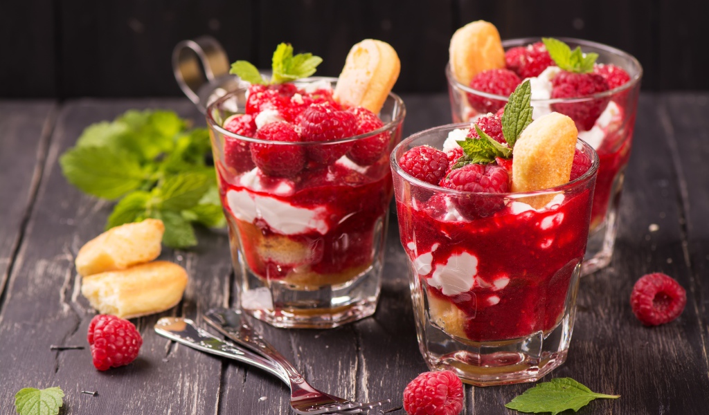 Десерт с печеньем и малиной на столе с вилками