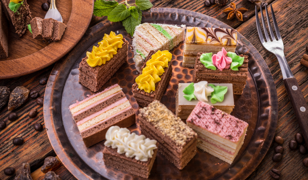 Разные вкусные пирожные на подносе 