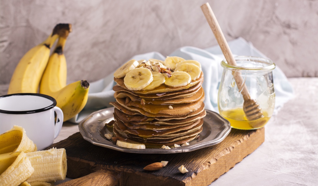 Оладьи с медом и бананами на столе