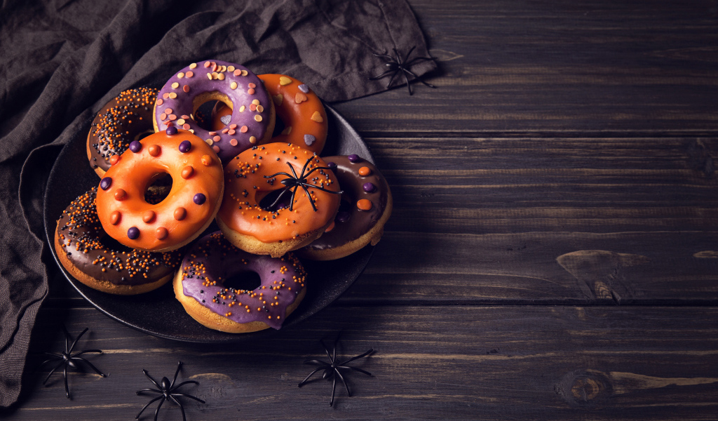 Пончики с глазурью на столе угощение на Хэллоуин 