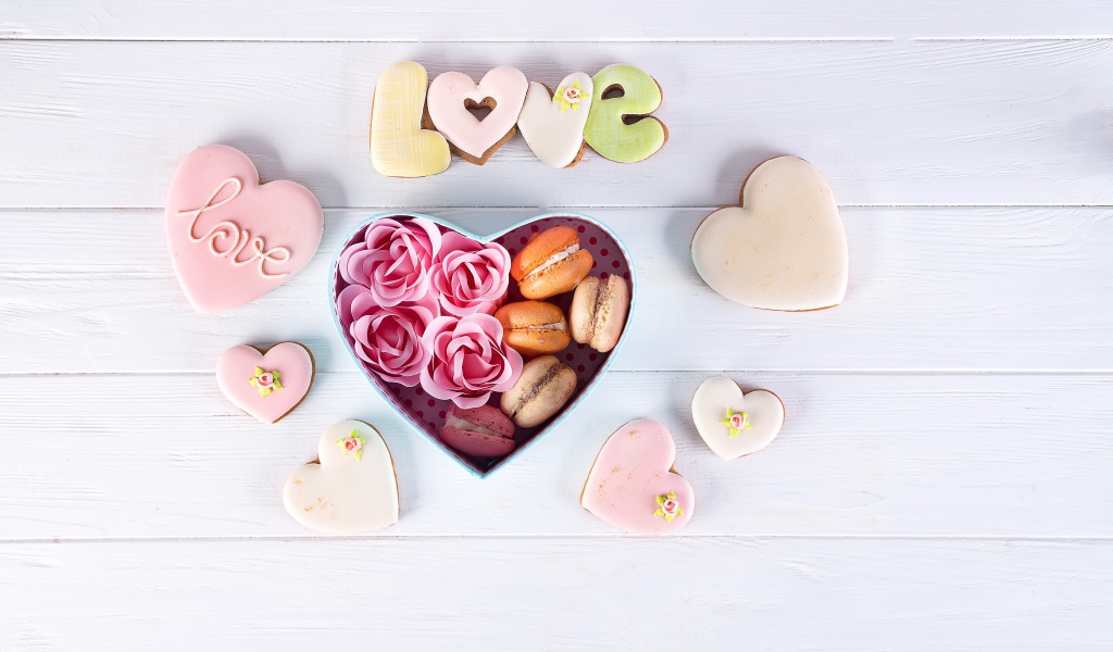 Печенье в форме сердца на столе с коробкой с десертом макарун