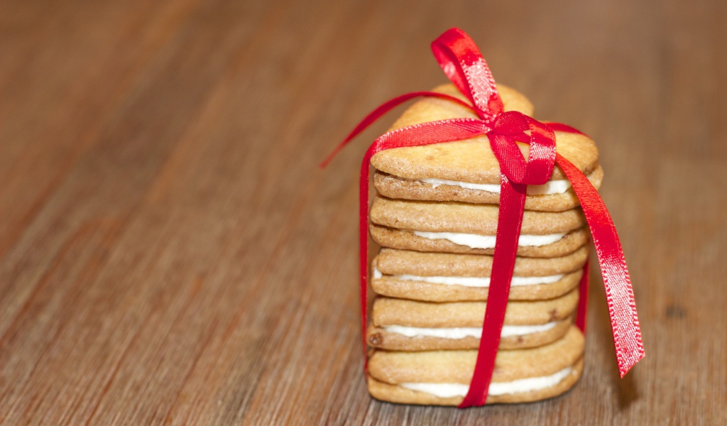 Печенье в форме сердца перевязано красной лентой 