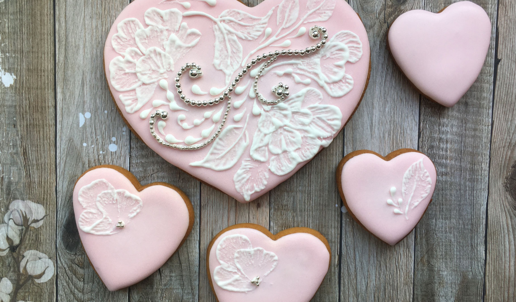Печенье в форме сердца с розовой глазурью на столе