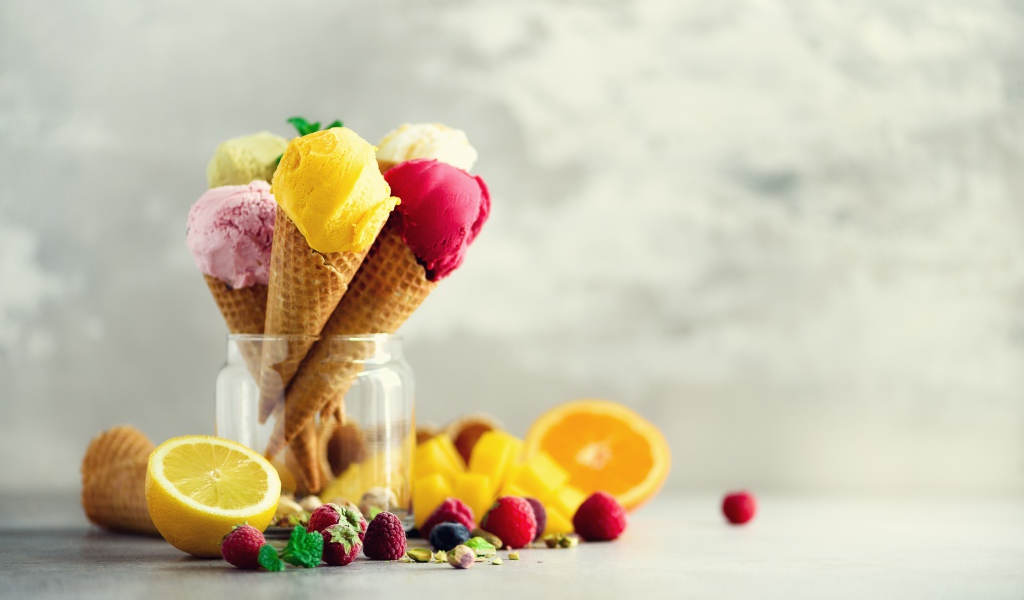 Фруктовое мороженое в вафельных рожках на столе с ягодами и фруктами