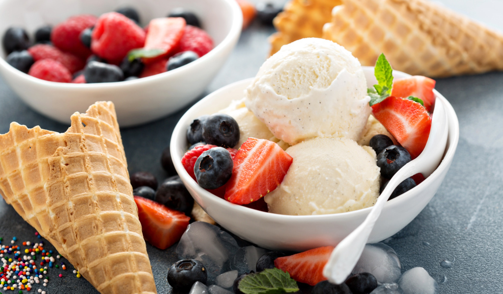 Мороженое с ягодами черники и клубники на столе с вафельными рожками